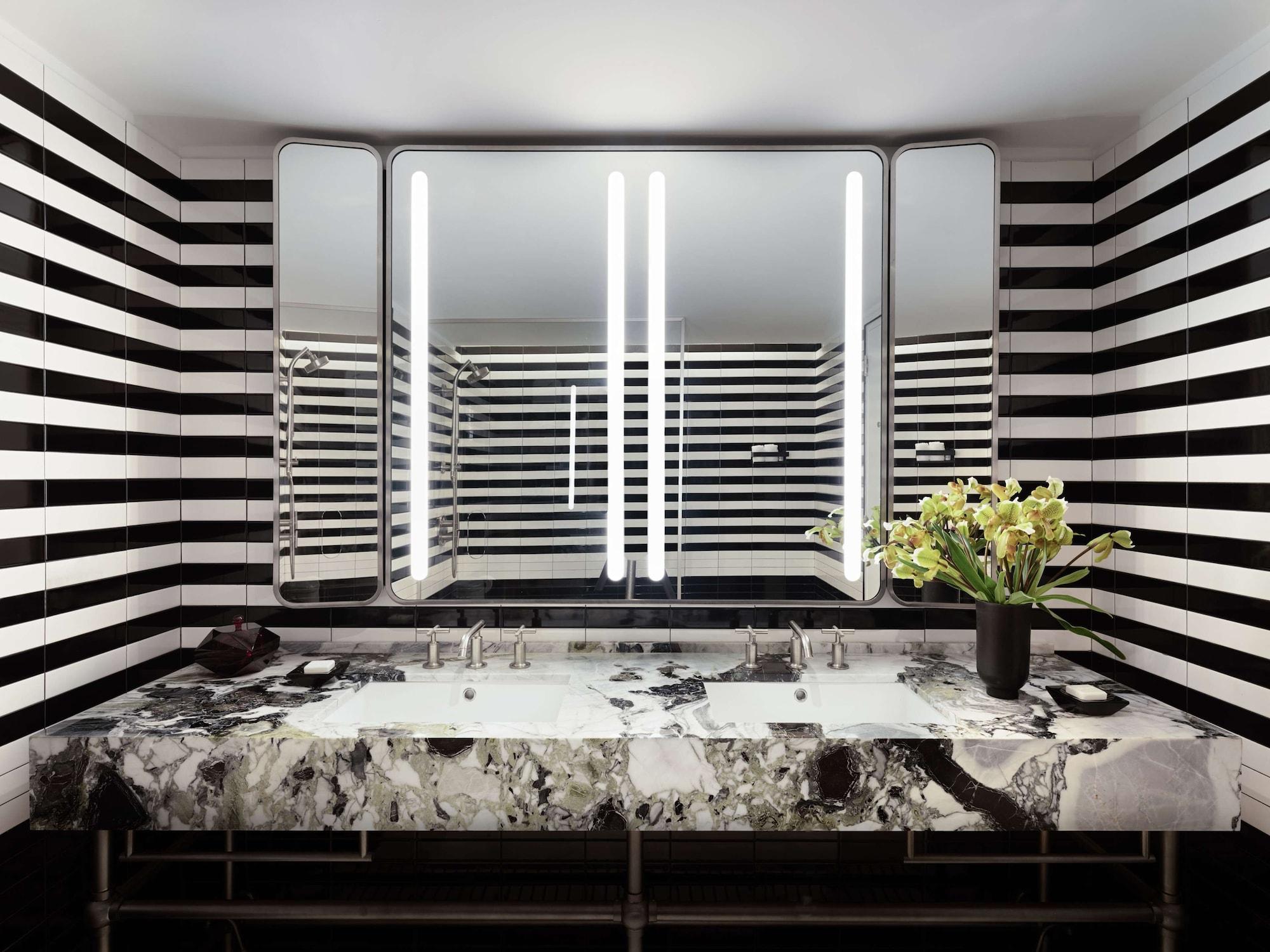 Park Lane New York酒店 外观 照片 The photo shows a modern bathroom featuring a stylish design. The walls are adorned with bold black and white stripes, creating a striking visual effect. In the center, there is a luxurious countertop made of marble, which complements the contemporar