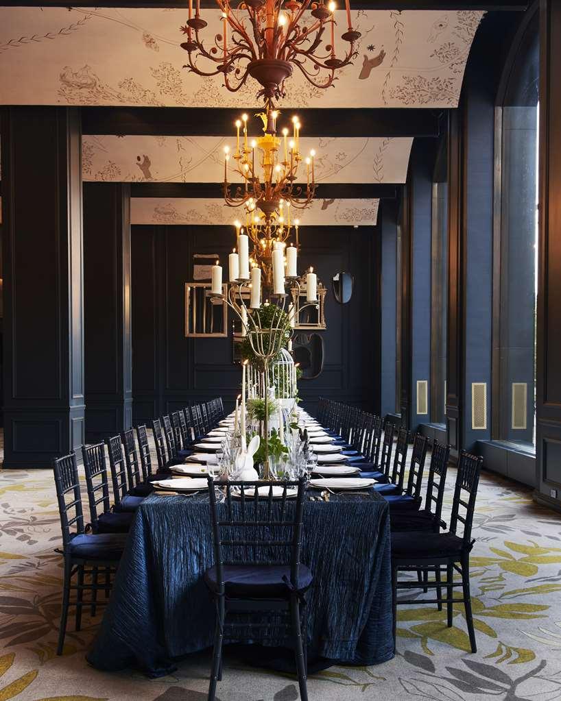 Park Lane New York酒店 设施 照片 The photo depicts an elegant dining room featuring a long table set for a formal gathering. The table is decorated with white plates and silverware, and there is a striking centerpiece with greenery and candles, adding a sophisticated touch. Above th