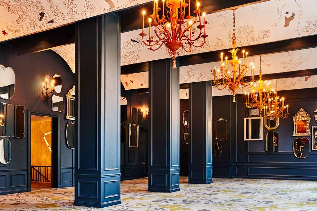 Park Lane New York酒店 设施 照片 The photo depicts an elegant interior space featuring high ceilings and large, dark columns. The walls are predominantly a deep shade, possibly navy or black, which creates a dramatic atmosphere. Ornate chandeliers hang from the ceiling, adding a tou